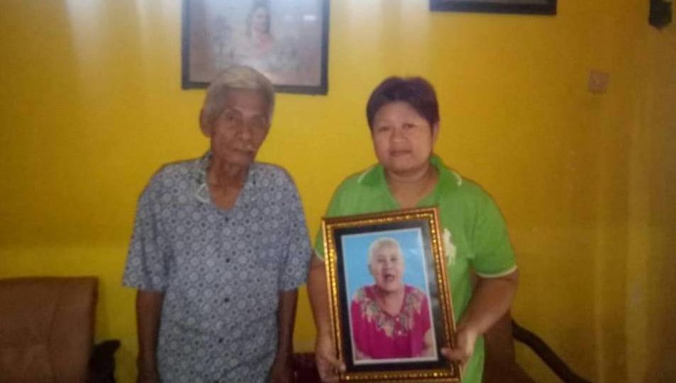 Family members holding up a photo of the late Bu Nunuk. Photo: Facebook/Aan Anshori