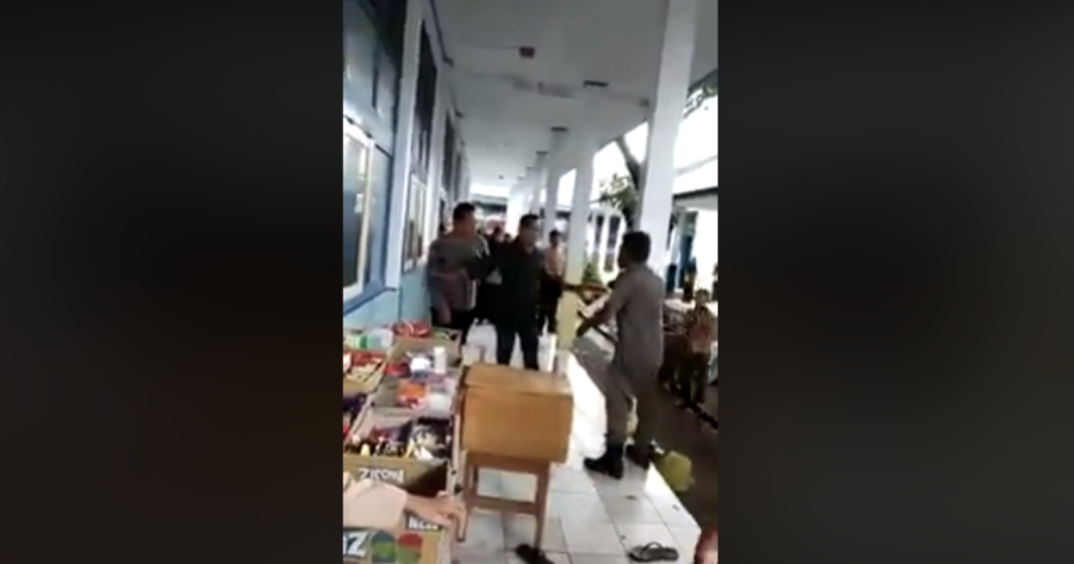 A video showing Rasul, father of one of the students, trying to attack Faisal, the school’s cleaner, while being held back by a school official has gone viral online. Photo: Facebook/Yuni Rusmini