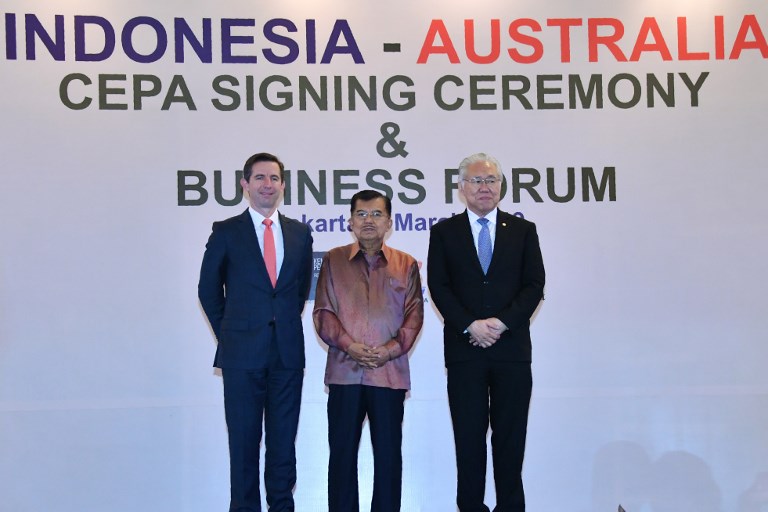 Indonesian Trade Minister Enggartiasto Lukita (R), his Autralian couterpart Simon Birmingham (L) and vice president Jusuf Kalla pose for a photo after a signing ceremony in Jakarta on March 4, 2019. – Indonesia and Australia on March 4, signed a long-awaited trade deal after months of diplomatic tension over Canberra’s contentious plan to move its embassy to Jerusalem. (Photo by ADEK BERRY / AFP)