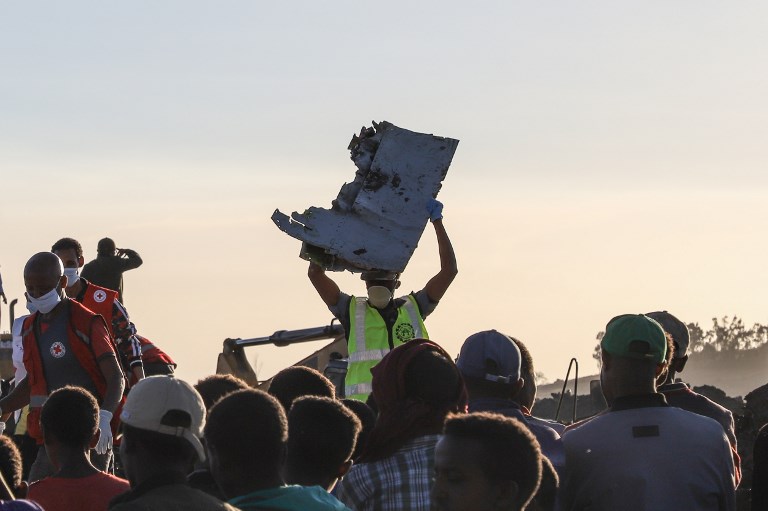 A man carries a piece of debris on his head at the crash site of a Nairobi-bound Ethiopian Airlines flight near Bishoftu, a town some 60 kilometres southeast of Addis Ababa, Ethiopia, on March 10, 2019. – A Nairobi-bound Ethiopian Airlines Boeing crashed minutes after takeoff from Addis Ababa on March 10, killing all eight crew and 149 passengers on board, including tourists, business travellers, and “at least a dozen” UN staff. (Photo by Michael TEWELDE / AFP)