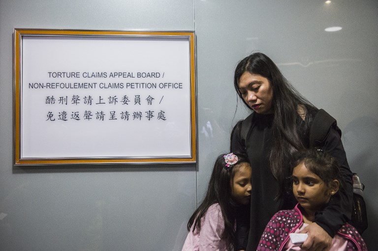 Filipino refugee Vanessa Rodel (center) with her daughter Keana (left) and Sethumdi, the daughter of Sri Lankan refugee Nadeeka Nonis (not pictured) outside an office of the Torture Claims Appeal Board building in Hong Kong on July 17, 2017, before attending an appeal hearing over the rejection of their refugee status in the southern Chinese city. (Photo: Isaac Lawrence/ AFP)
