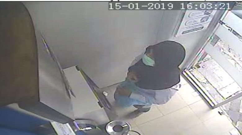 CCTV footage allegedly showing Ramyadjie Priambodo using a headscarf and masker to conceal his identity while carrying out an ATM skimming scam. Photo: Istimewa