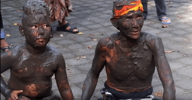 Balinese people smother themselves in mud as part of a newly-reinstated ritual where they then head to beach to wash the mud and their sins away (Photo: Helga Christ / YouTube screengrab)