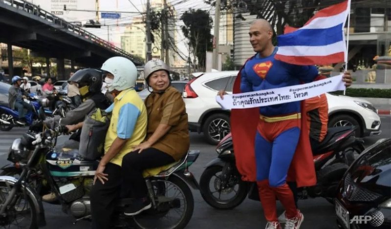 'If you love Thailand: Vote,' says the banner Pfizenmaier carries on his quest. (Photo: AFP/Lillian SUWANRUMPHA) 