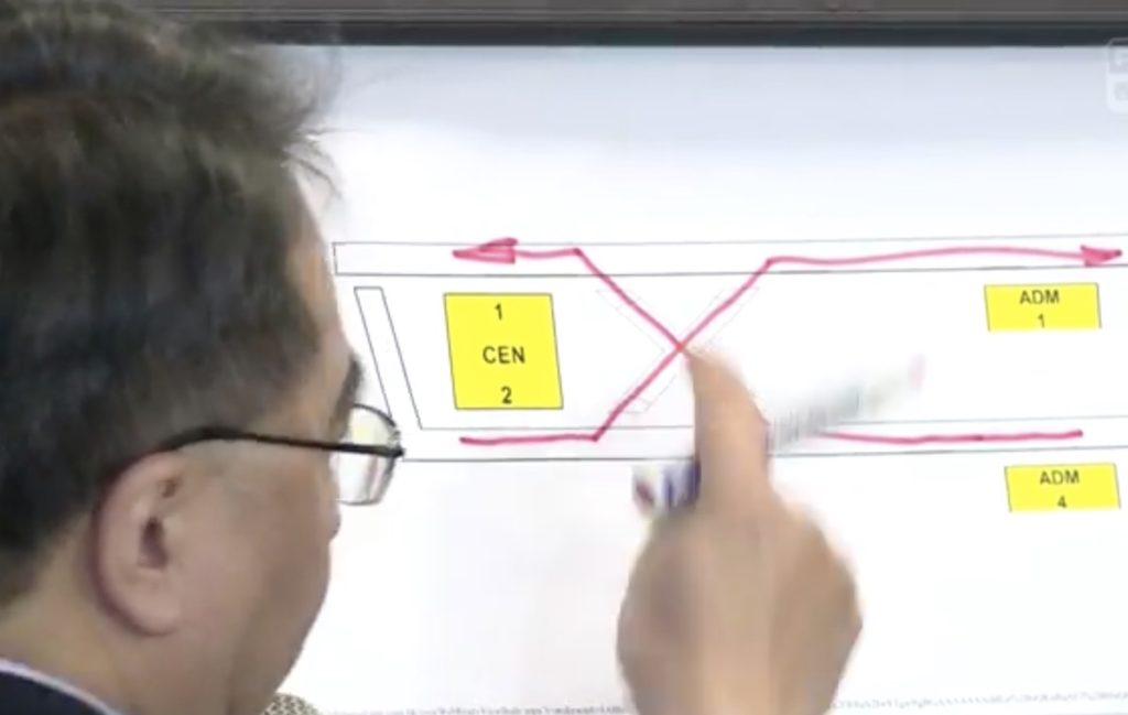 Jacob Kam demonstrates on a white board how the trains collided. Screengrab via Facebook video/RTHK.