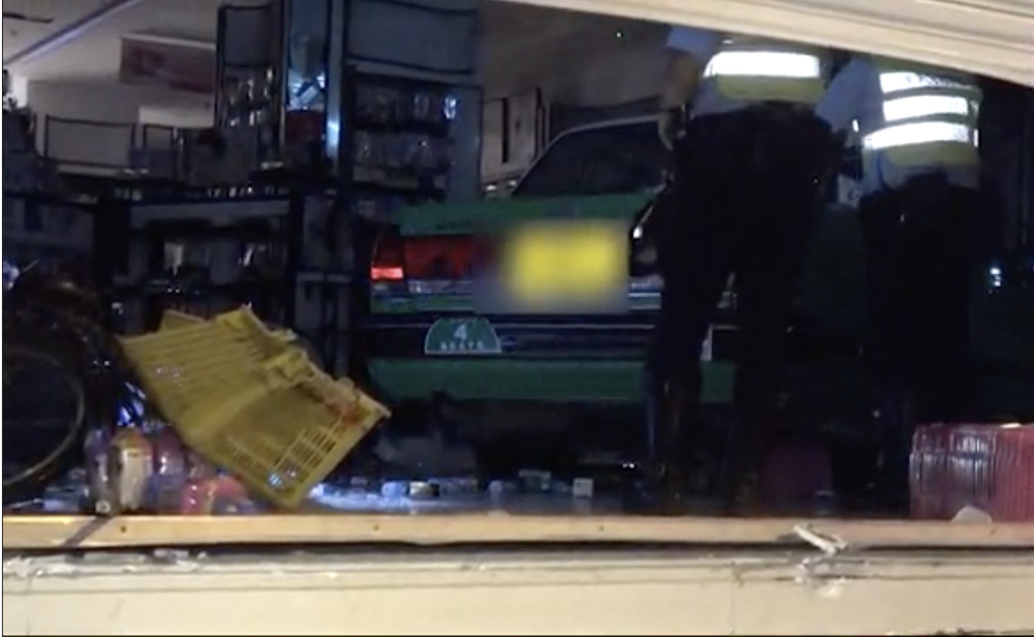 Police arrive at the scene of a Sasa comsmetics store in Sheung Shui where a cab rammed through the store front in the early hours of this morning. Screengrab via Apple Daily video.