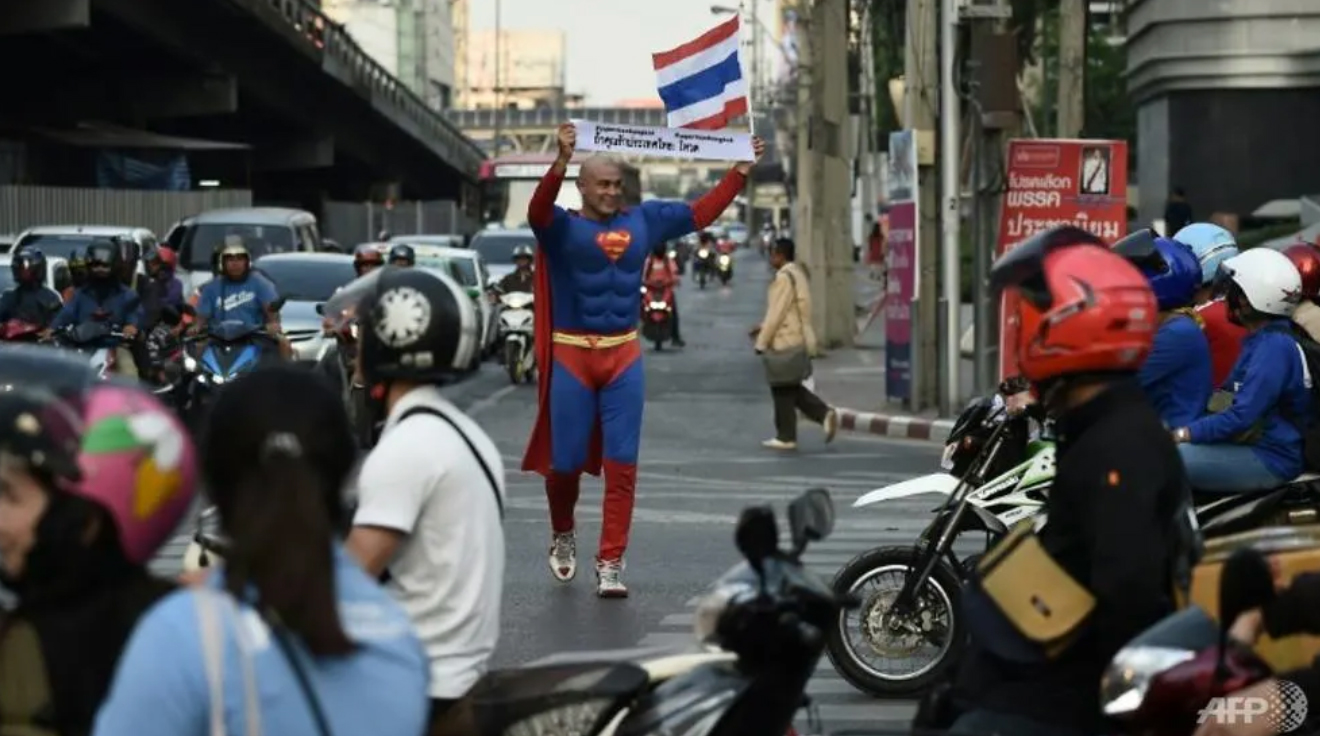 In his quest to encourage voters, Pfizenmaier has spread his message at universities, sidewalks and busy intersections, carrying a Thai flag and posing for countless selfies. (Photo: AFP/Lillian SUWANRUMPHA) 