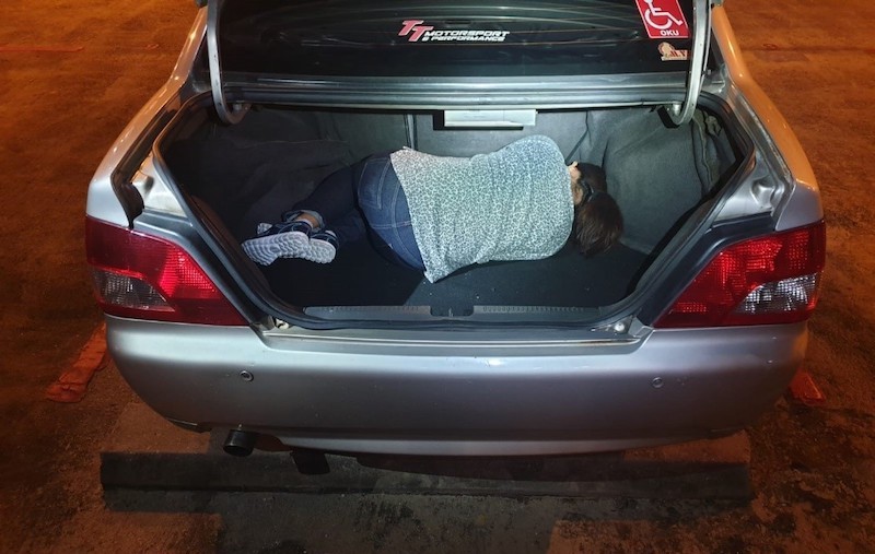 The Myanmar national hiding in the boot of a car. Photo: ICA newsroom
