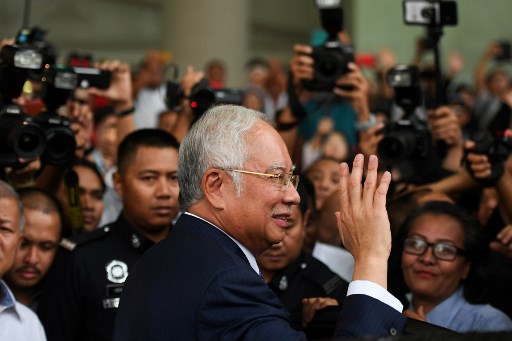 Malaysia’s former prime minister Najib Razak waves as he leaves a court in Kuala Lumpur on April 3, 2019, after his trial over alleged involvement in the looting of sovereign wealth fund 1MDB, a state investment vehicle established to develop the economy of the Southeast Asian nation. – Malaysia’s disgraced former leader Najib Razak pleaded not guilty to all charges against him as he went on trial April 3 over a multi-billion-dollar fraud. (Photo by Mohd RASFAN / AFP)