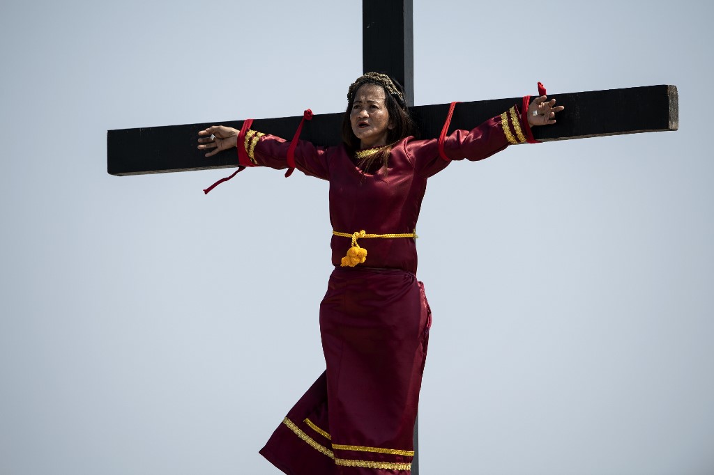 A female Philippine Christian devotee is nailed to a cross during a reenactment of the Crucifixion of Christ during Good Friday ahead of Easter in the village of Cutud near San Fernando on April 19, 2019. - Frowned upon by the Church, the ritual crucifixions and self-flagellation in the north of the country are extreme affirmations of faith performed every Easter in Asia's Catholic outpost. (Photo by Noel CELIS / AFP)