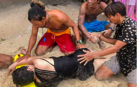 The woman receiving treatment from a Bali lifesaving officer. Photo: @denpasar.viral/Balawisata