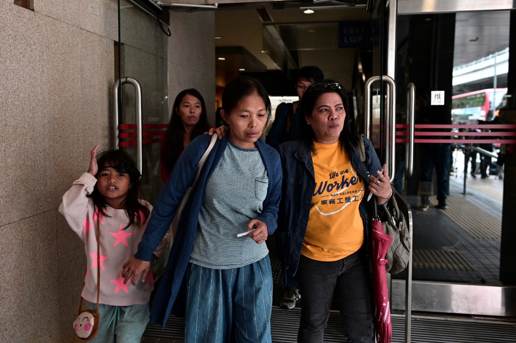 Baby Jane Allas (center) leaves with family members and supporters after a hearing at the Labour Tribunal in Hong Kong on Monday. Photo via AFP.