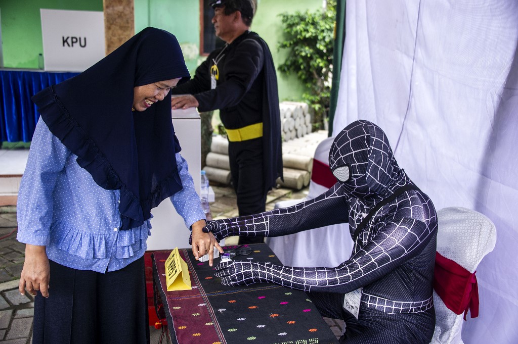 Indonesian election workers dressed in superhero costumes register voters at a polling station in Surabaya on April 17, 2019. Juni Kriswanto / AFP