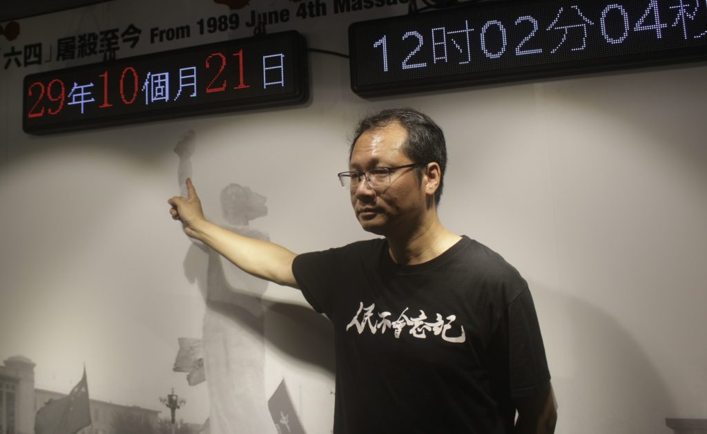 Vice chair of the Hong Kong Alliance in Support of Patriotic Democratic Movements in China Richard Tsoi pointing to a clock counting down the days and minutes since the Tiananmen Square Massacre at the June 4 Museum. Photo by Vicky Wong.