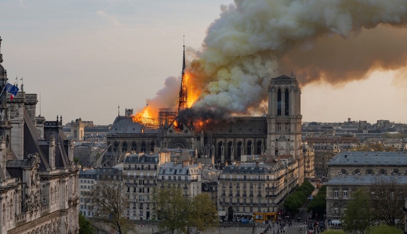 A huge fire swept through the roof of the famed Notre-Dame Cathedral in central Paris on April 15, 2019, sending flames and huge clouds of grey smoke billowing into the sky. The flames and smoke plumed from the spire and roof of the gothic cathedral, visited by millions of people a year. Photo: Fabien Barrau/AFP