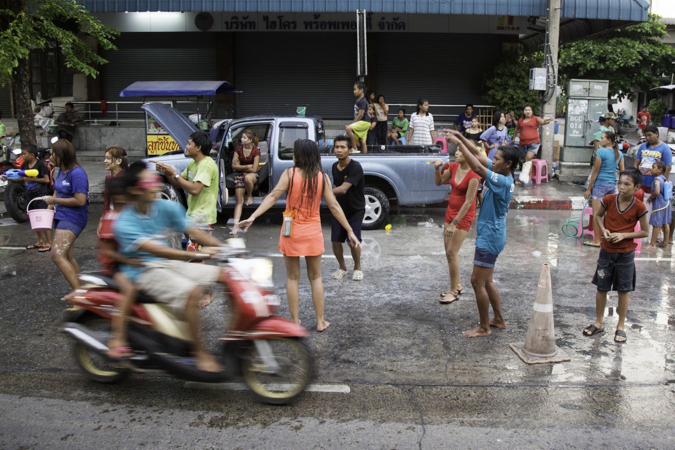 A motorcycle careens by Songkran revelers ready to splash passing vehicles in a 2015 file photo taken in Bangkok’s Min Buri district. Photo: Alexander Hotz/Coconuts Media