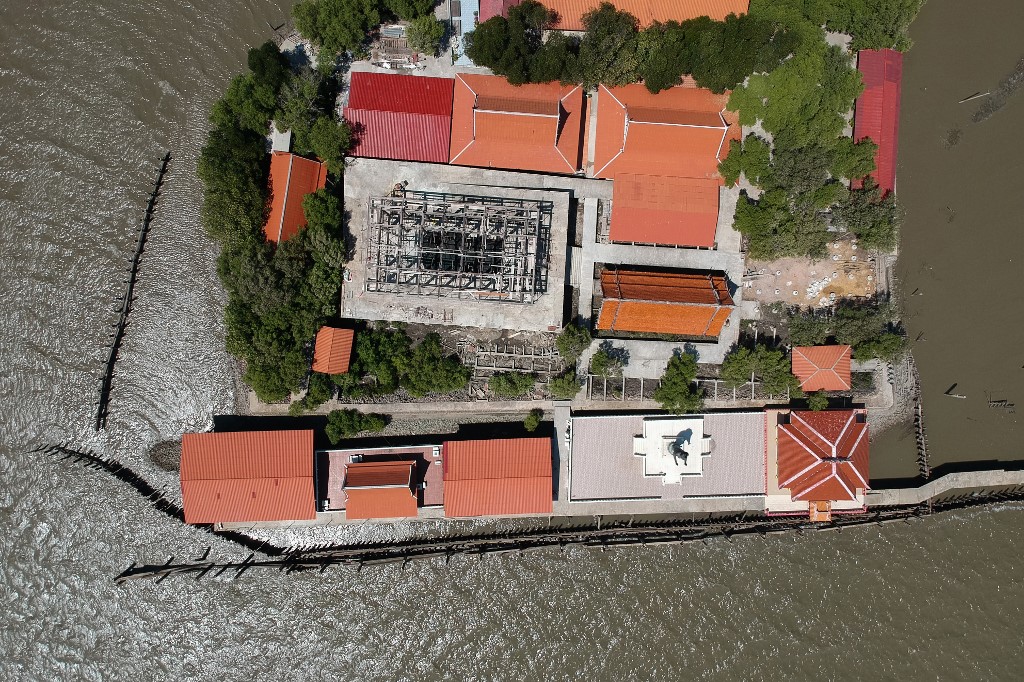 This aerial photo taken on March 9, 2019 shows a view of a Buddhist temple isolated by coastal erosion in Samut Chin village, off the shore of Samut Prakan. – A Buddhist temple in Thailand now lost in the middle of the sea became a symbol of coastal erosion… but locals place their hopes in the replanting of mangrove. Jonathan Klein / AFP
