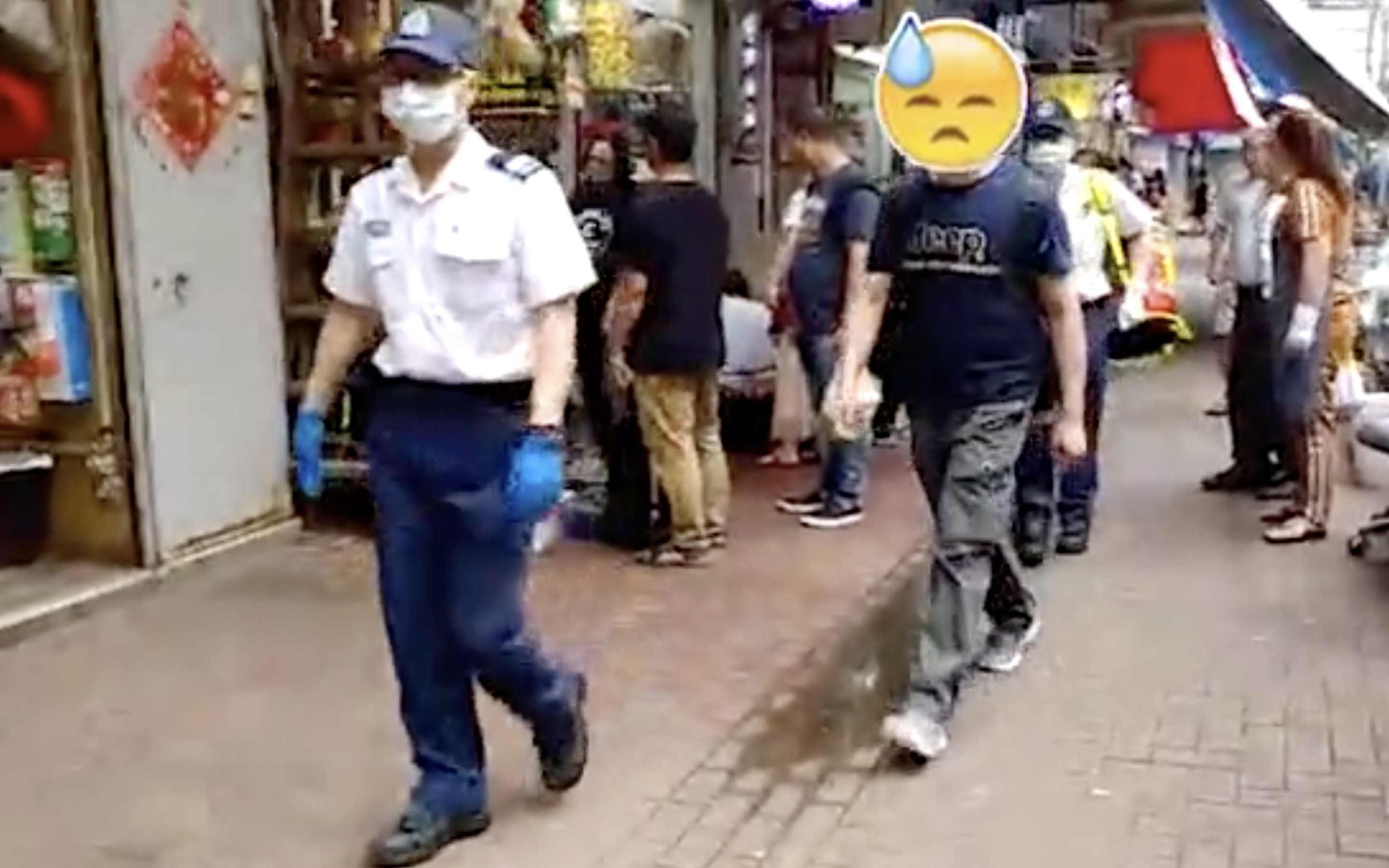 The victim of an attempted robbery is escorted by police in Tuen Wan yesterday. Screengrab via Apple Daily video.