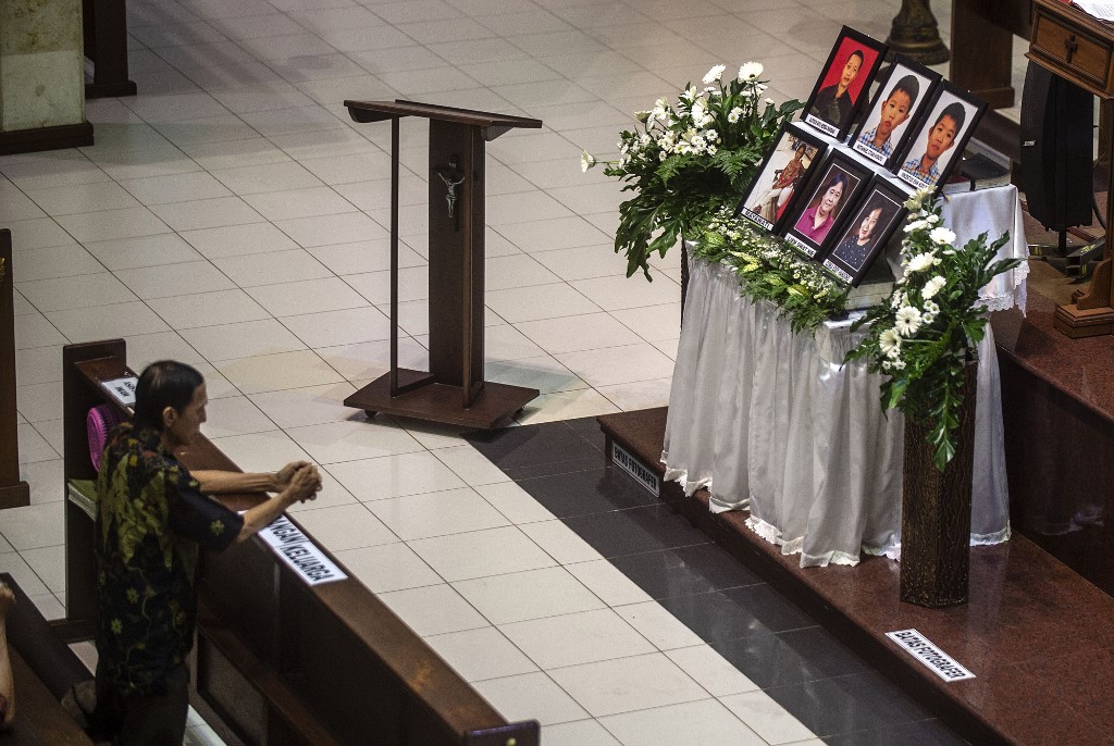 A man attends a memorial service at Santa Maria Catholic Church in Surabaya on May 13, 2019, to remember the victims of suicide bombings carried out by an Islamic State-inspired family. – On May 13, 2018, a family of six — including two girls aged nine and 12 — blew themselves up at the Santa Maria Catholic Church and two other churches in Surabaya during Sunday morning services, killing over a dozen congregants and wounding scores more. (Photo by Juni Kriswanto / AFP)