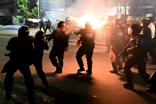 Indonesian police officers shoot tear gas to disperse protesters during a demonstration outside the Elections Oversight Body (Bawaslu) in Jakarta on May 22, 2019. (Photo by BAY ISMOYO / AFP)