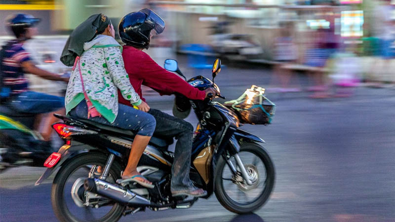 A motorbike zooms down a busy Bangkok street in 2017.
