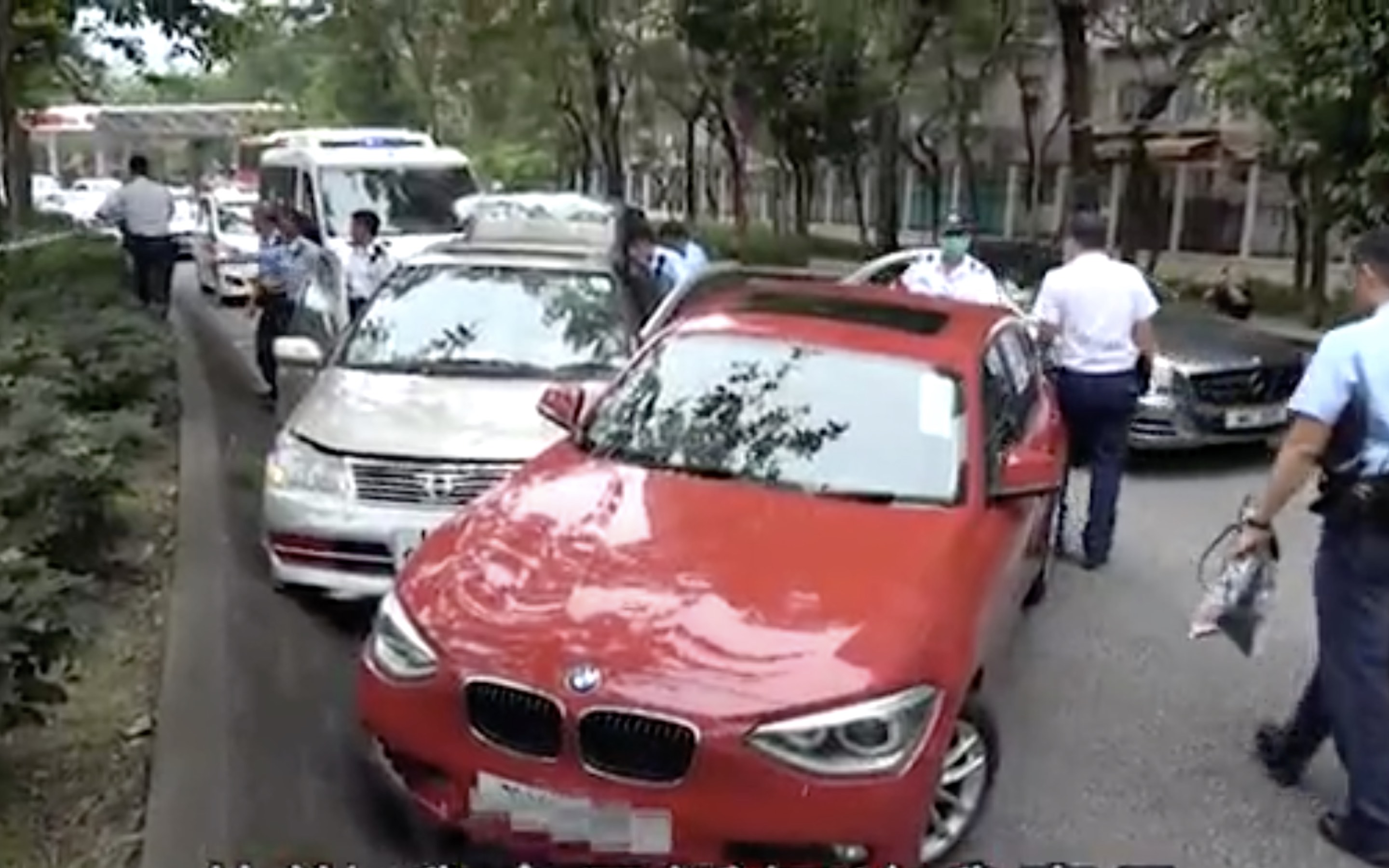A man who attempted to steal a woman’s handbag was apprehended after the woman pursued him by hanging onto the steering wheel of his car, and her husband cornered him with his car. Screengrab via Apple Daily video.