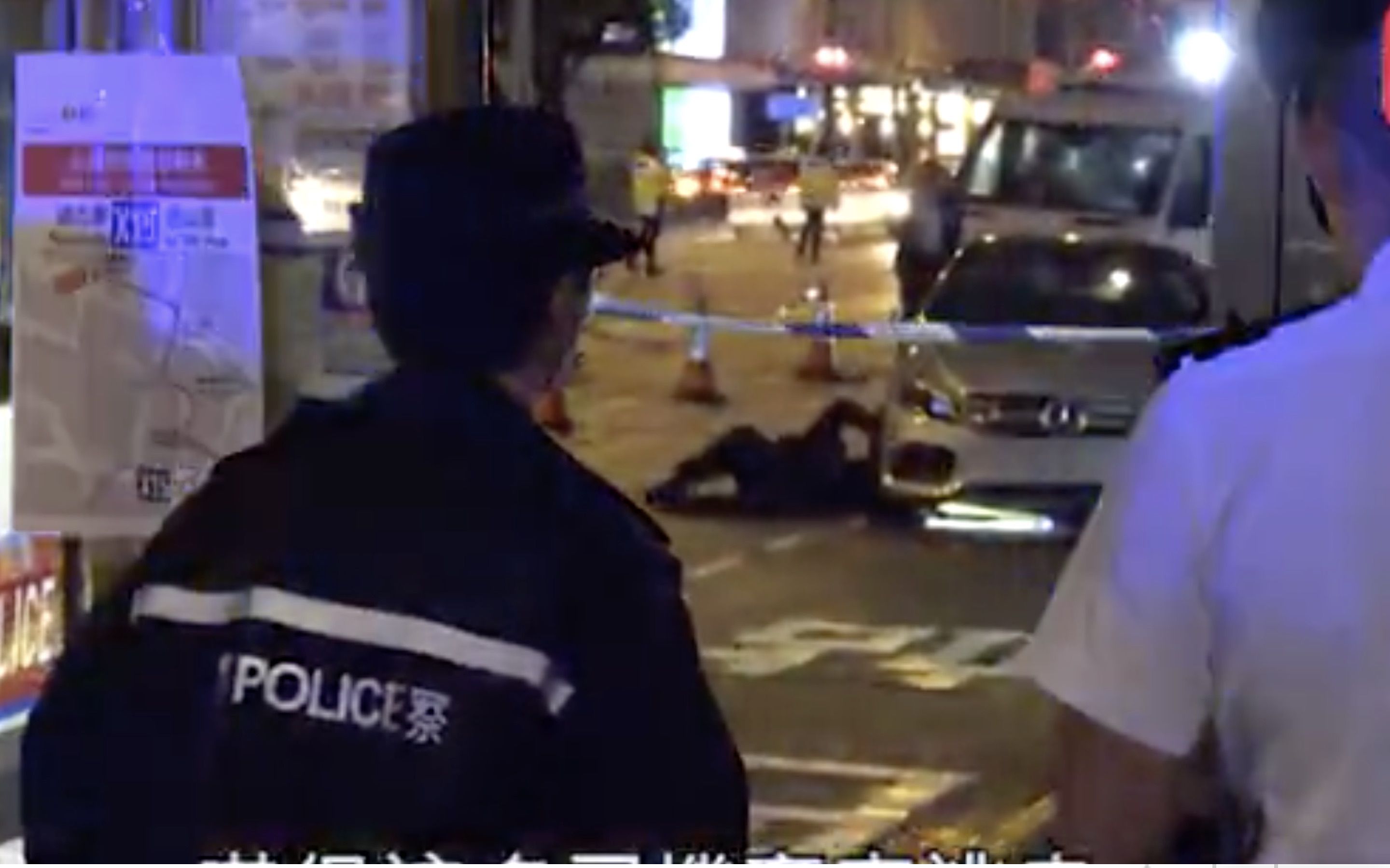 Police officers looking underneath a Mercedes Benz after it drove over a teargas canister in Central. Screengrab via Apple Daily video.
