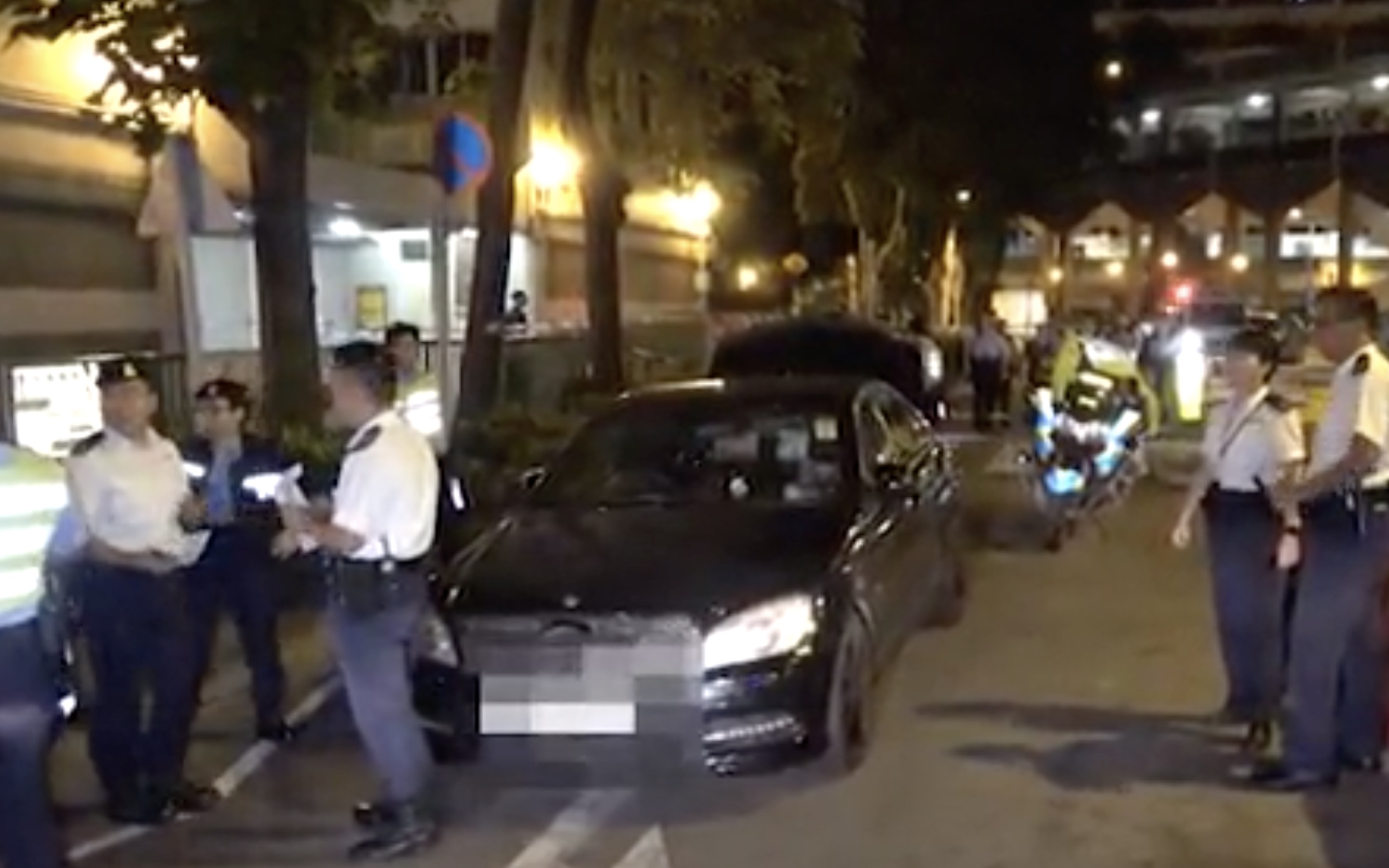 Police at the scene where an officer shot at a driver that allegedly tried to run him over with his Mercedes Benz. Screengrab via Apple Daily video.