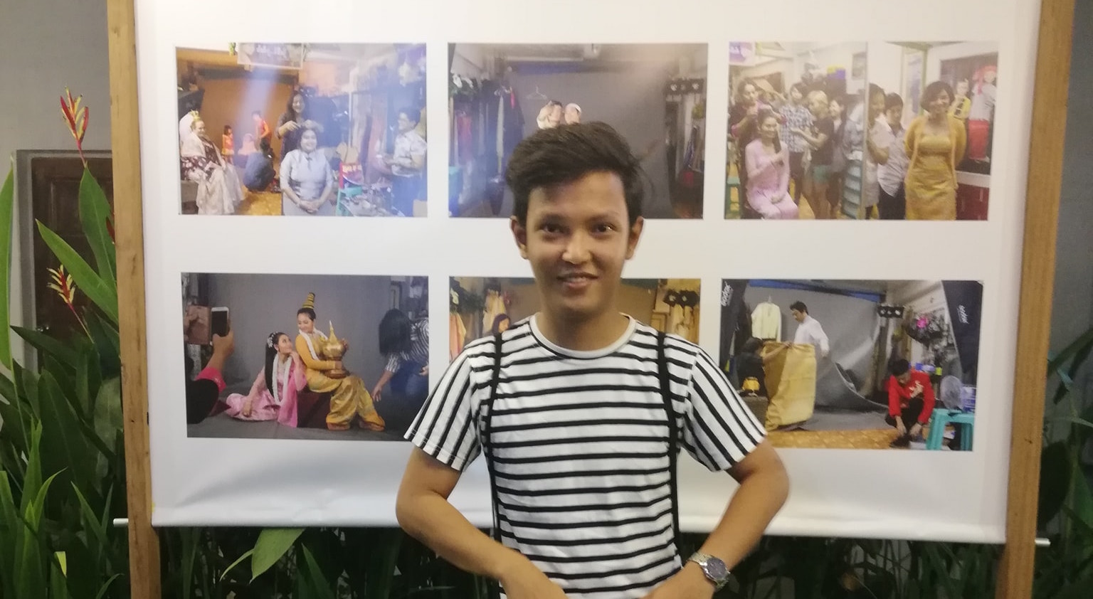 Kyaw Zin Win posing in front of photo exhibit at French Institute via Facebook