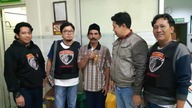 Hori bin Suari (middle) photographed with police officers. Photo: Lumajang Police
