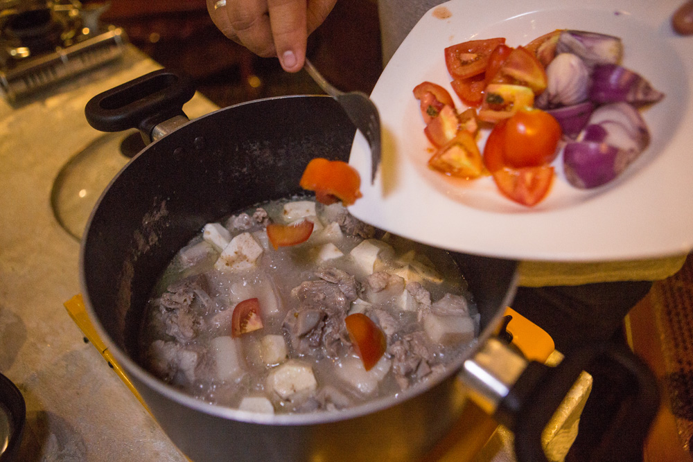 Vegetables being added to the sinigang. (Photo: Jacques Manuntag/Coconuts)