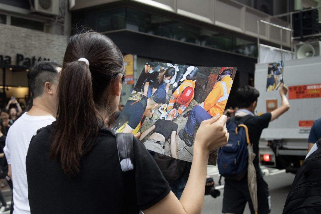 Many protesters carried photos of those injured in another demonstration on Wednesday that descended into violence. Photo by Samantha Mei Topp.