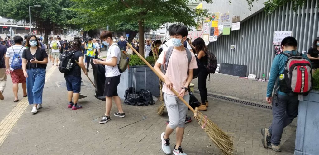 Some protesters join in clean-up efforts as resolve to continue blocking Harcourt Road wanes. Photo by Vicky Wong.