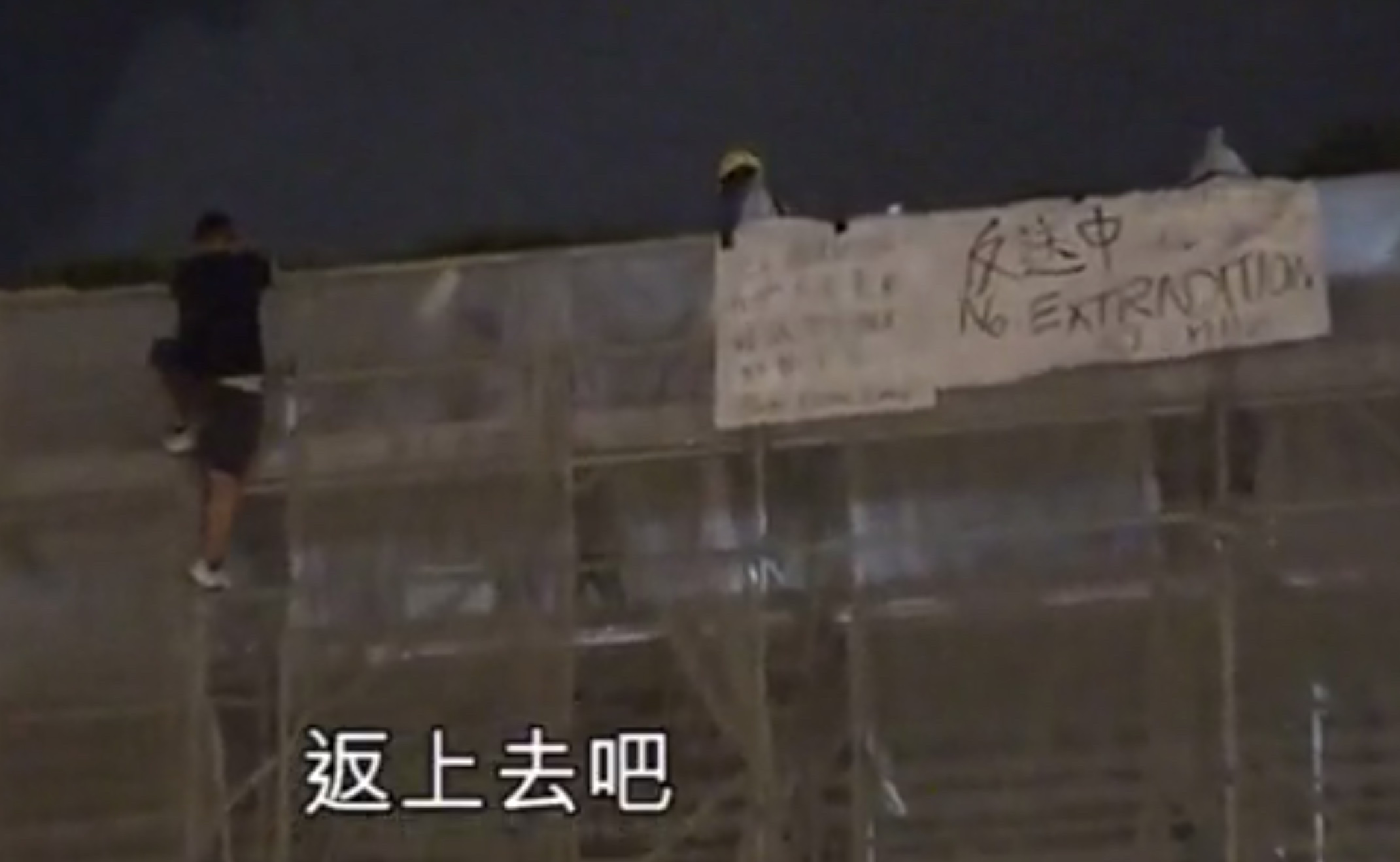 An anti-extradition bill protester clings to some scaffolding outside Pacific Place shortly before falling to his death. Screengrab via Apple Daily video.