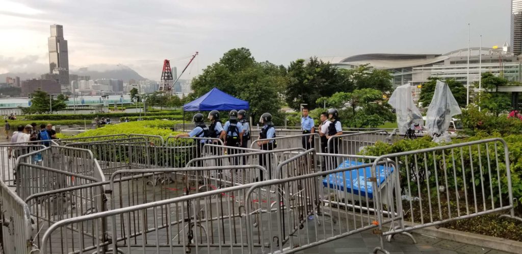 Police standing behind barricades made by protesters blocking people from entering the Central Government Complex. Photo by Vicky Wong.
