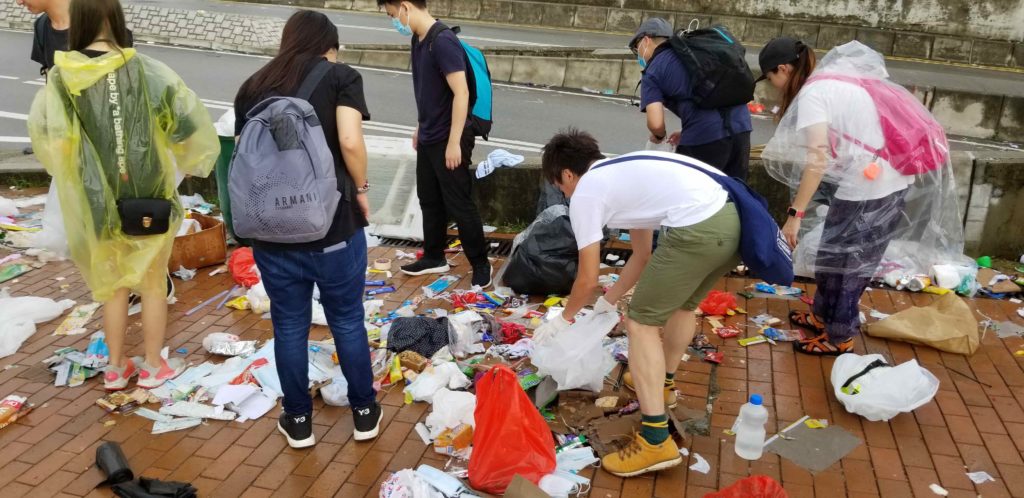 Protesters cleaning up trash left over from yesterday's protest against the extradition bill. Photo by Vicky Wong.