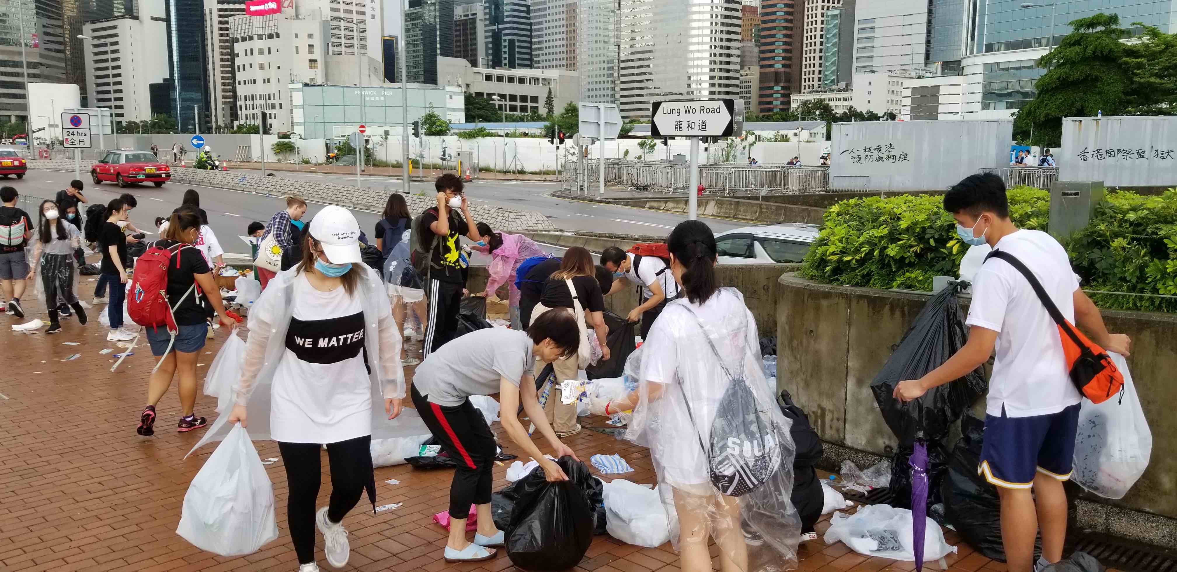 Protesters cleaning up trash left over from yesterday’s protest against the extradition bill. Photo by Vicky Wong.