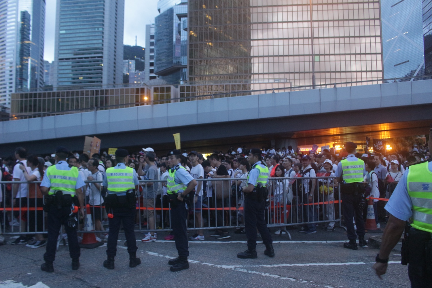 Police man a barricade as anti-extradition protesters file by on Sunday. Photo by Vicky Wong.