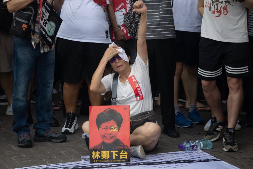 A protester at a peaceful anti-extradition bill march takes a break from the humidity on Sunday. Photo by Samantha Mei Topp.