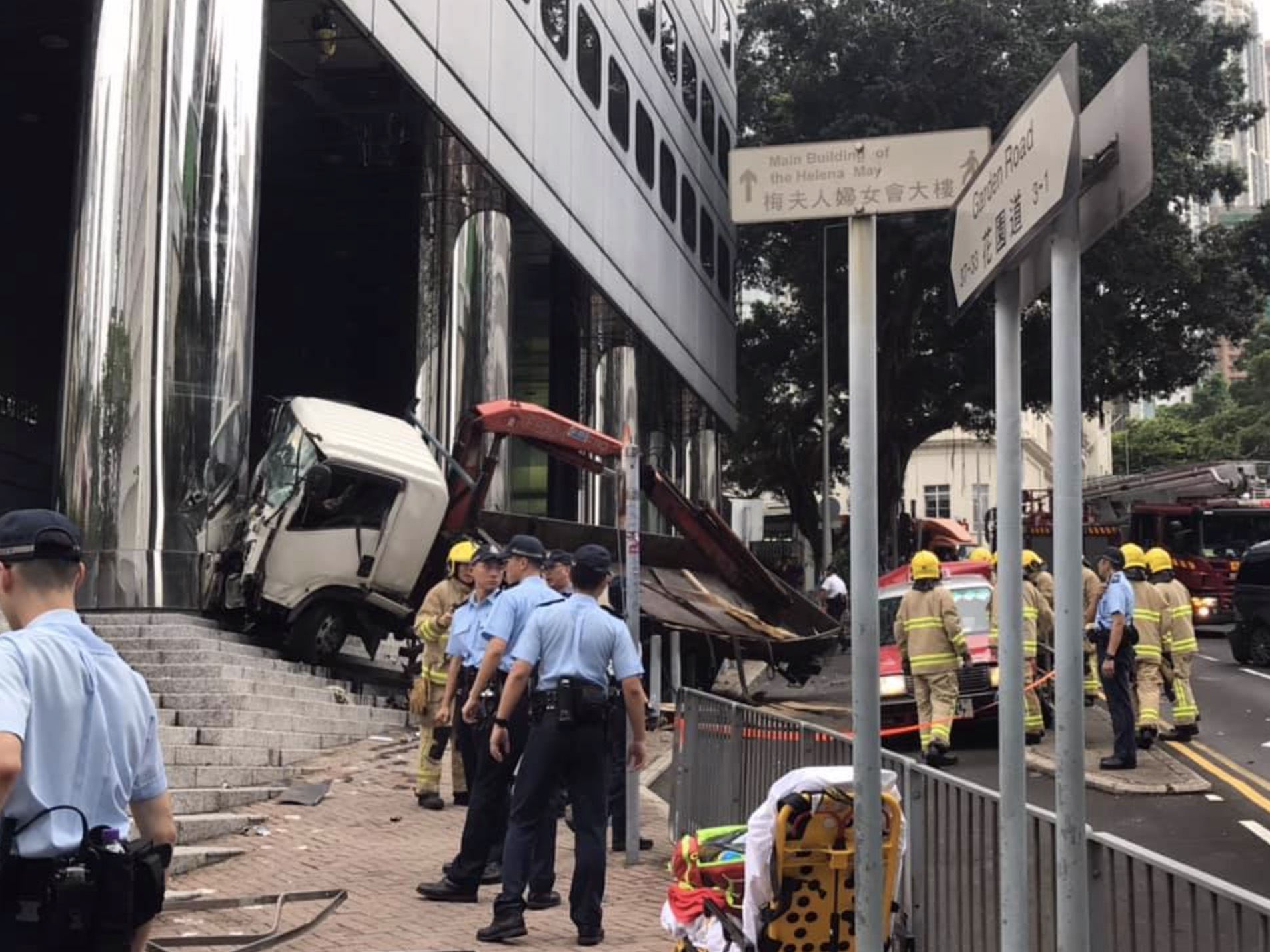 Police investigate the scene after a truck rammed into the back of a taxi on Garden Road this afternoon. Photo via Facebook/
‎Ngo Wk.