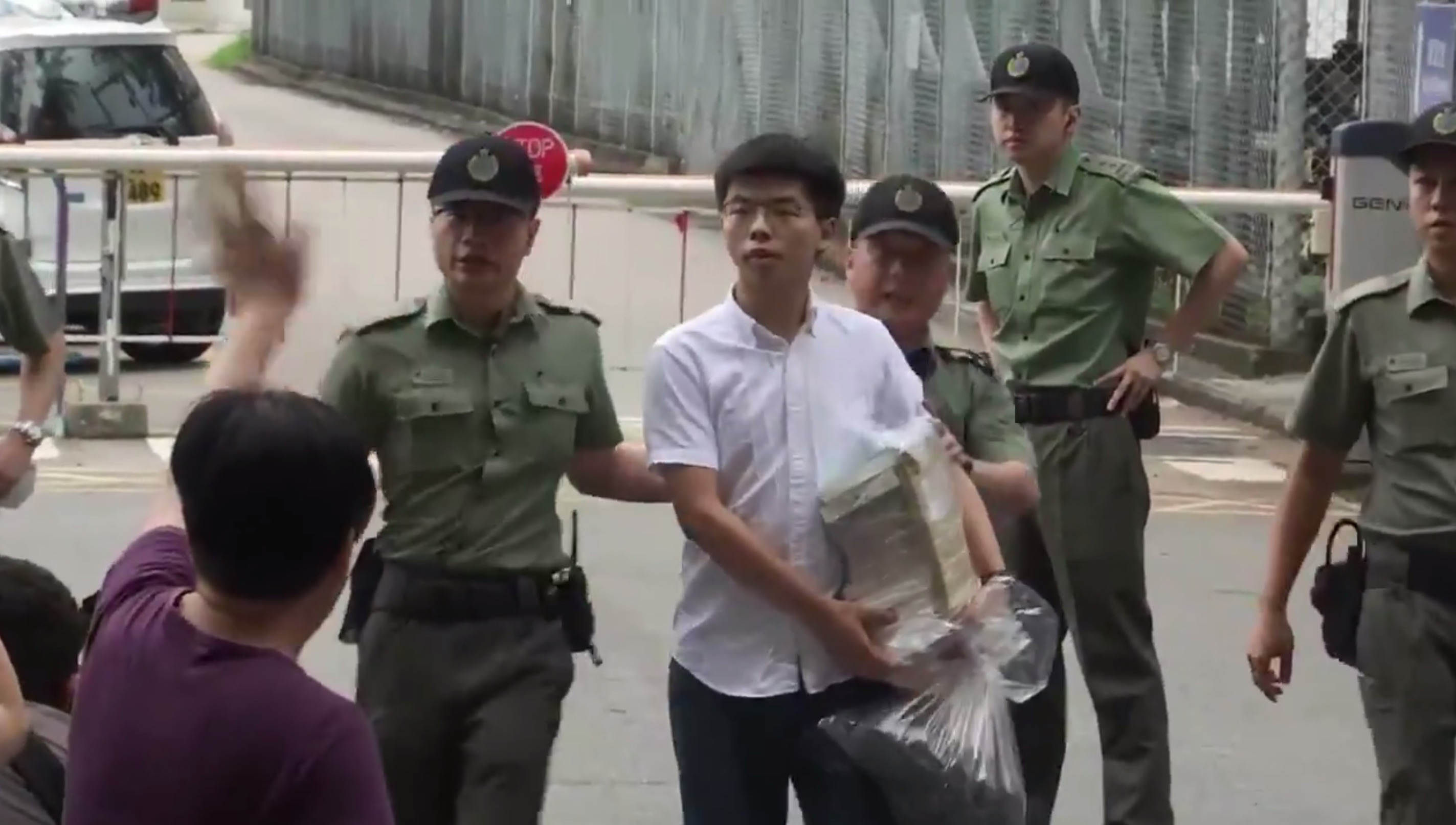 Pro-democracy activist Joshua Wong walks out of the Lai Chi Kok Correctional Institute this morning. Screengrab via Twitter.