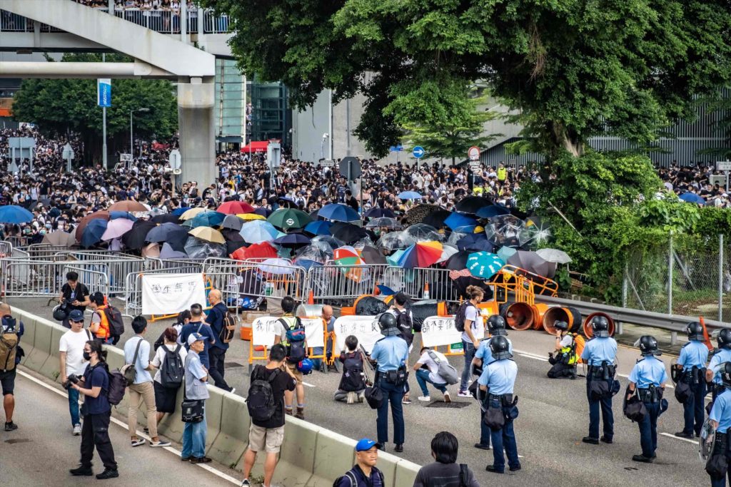Police and protesters facing off during an extradition bill protest. Photo by Tomas Wiik.