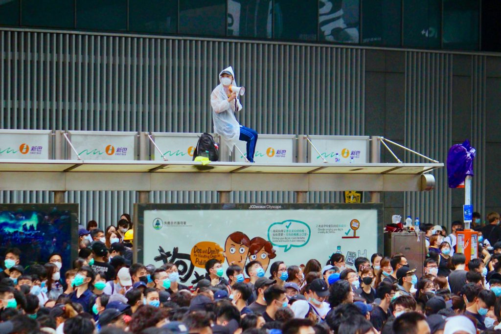 A protester sits on top of a bus stop on Connaught Road Central during a protest against a controversial extradition bill. Photo by Vicky Wong.