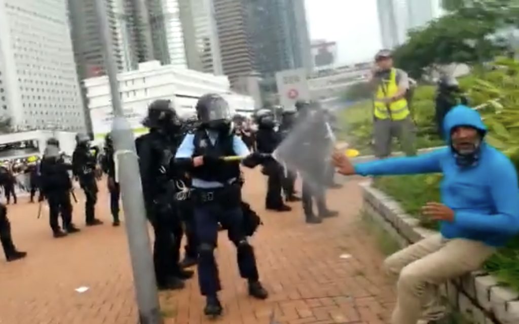 Man getting sprayed by police who were clearing out Lung Wo Road during the extradition bill protests. Screengrab via Apple Daily video.