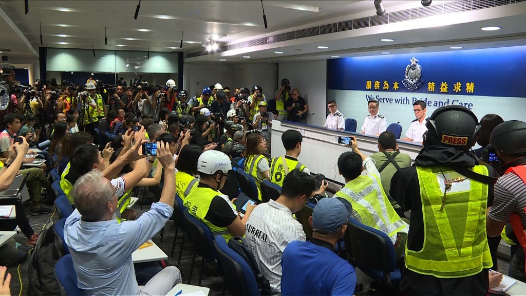 This still image taken from an AFPTV video shows Hong Kong journalists dressed in high visibility jackets and helmets during a police press conference to protest what they said was excessive force used against them during the June 12 clashes between police and protesters against a controversial extradition law proposal, in Hong Kong on June 13, 2019. – Hong Kong protest leaders announced plans for another mass rally on June 16, escalating their campaign against a China extradition bill a day after police cleared them from the streets using volleys of tear gas and rubber bullets. (Photo by AFPTV team / AFPTV / AFP)