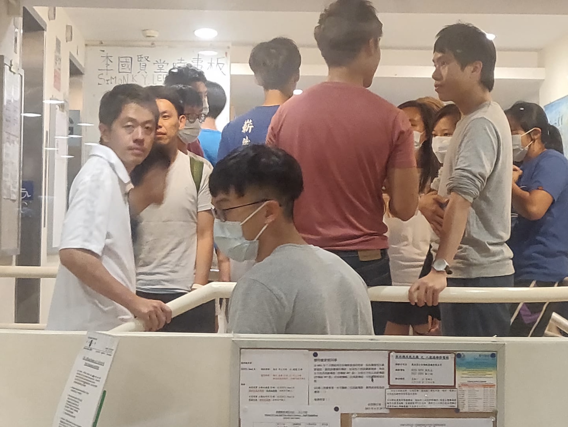 Lawmakers Ted Hui (far left) and Roy Kwong (far right) inside the lobby of the Simon K.Y. Lee Hall at the University of Hong Kong, following reports that police had a search warrant for the dorm, Photo via Facebook/Campus TV.