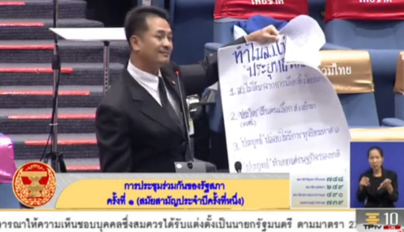 Pheu Thai MP Cholnan Srikaew displays a poster detailing why Gen. Prayuth Chan-o-cha is unfit to serve as prime minister Wednesday in Bangkok.
