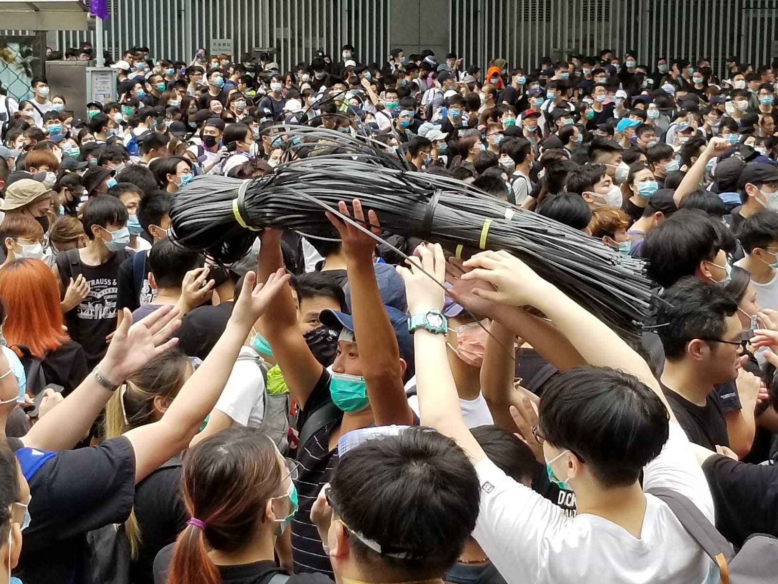 Protesters could be heard shouting for gloves, goggles, and zip ties — used to create makeshift ramparts by tying together police barricades. Cheers were let out as supplies passed through the crowd. Photo: Coconuts Hong Kong