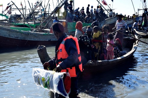 Myanmar Navy personnel escort Rohingya Muslims back to their camp in Sittwe, Rakhine state, on November 30, 2018. – Nearly 100 Rohingya Muslims were forced back to Myanmar’s Rakhine state after being detained at sea en route to Malaysia, police said on November 28, stirring fears of a fresh refugee boat crisis. (Photo by – / AFP)