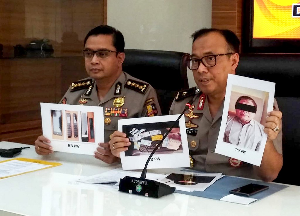 Indonesian police personnel show photographs of leader Para Wijayanto and various seized items, at a press conference in Jakarta on July 1, 2019, as Wijayanto was detained by counter-terrorism police with his wife on at a hotel in Bekasi, a city on the outskirts of the capital Jakarta. – Indonesian police said on July 1 they had arrested the leader of Al Qaeda-linked extremist network Jemaah Islamiah, which carried out the 2002 Bali bombings that killed more than 200 people. (Photo by STR / AFP)